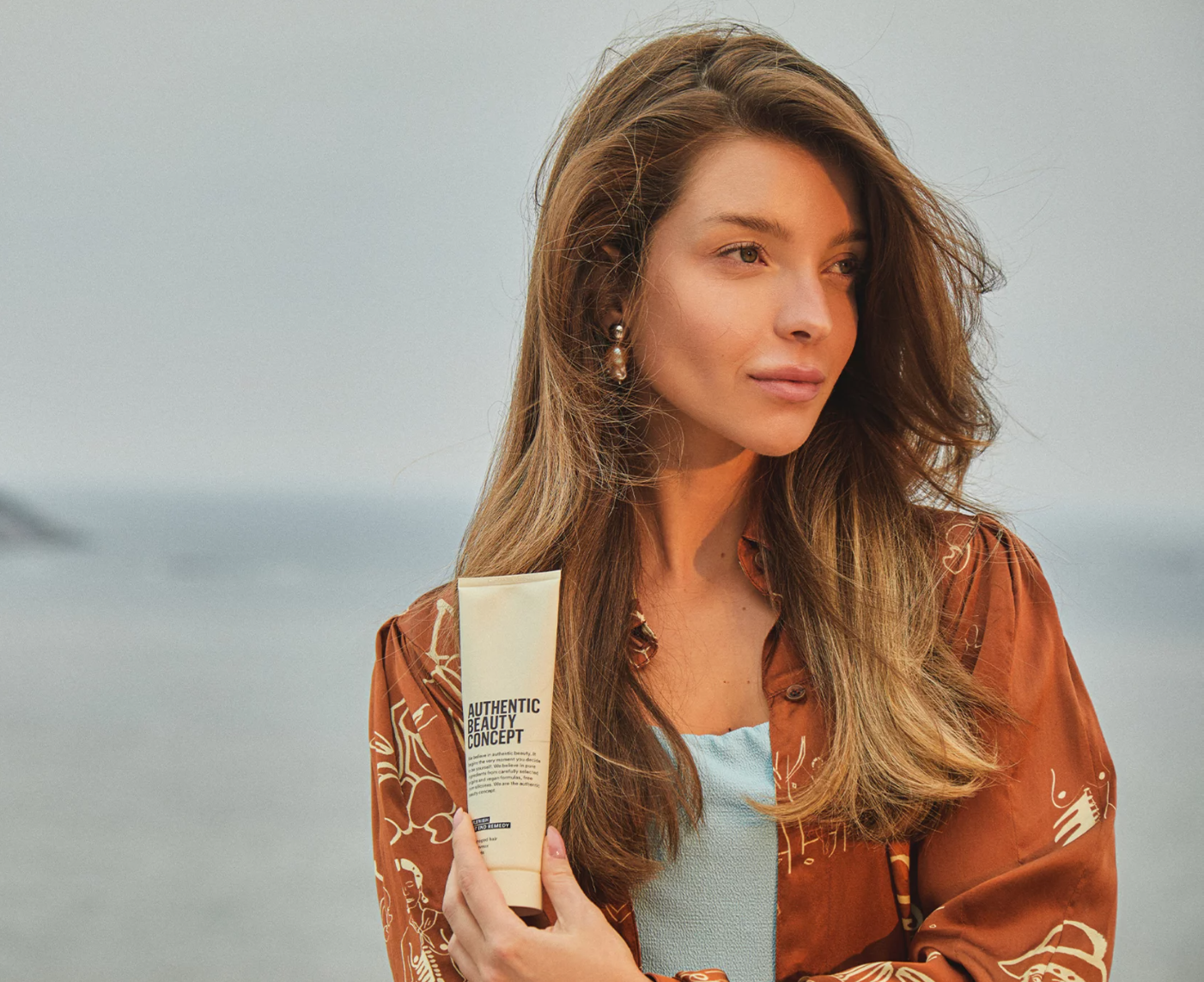 Henkilö pitää kädessään Authentic Beauty tuotetta