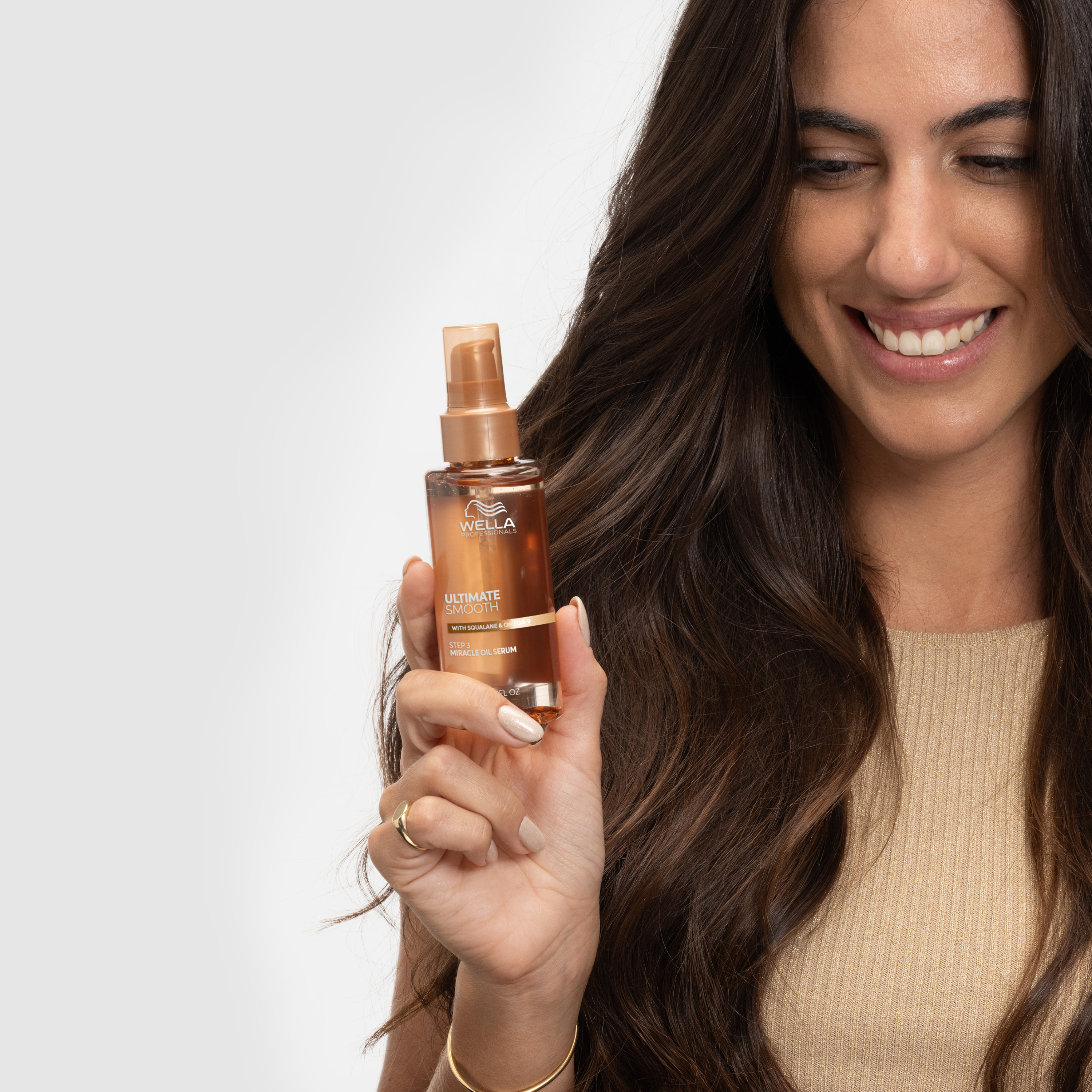 Henkilö pitää kädessään Ultimate smooth Miracle oil serum -tuotetta